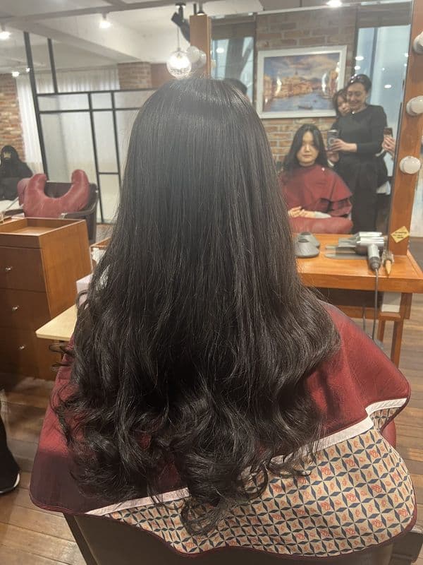 Long dark hair with large waves after a Korean digital perm at a Seoul academy seminar